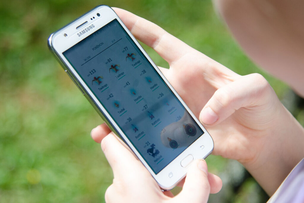 Närbild på en person som spelar Pokémon Go via sin mobiltelefon.